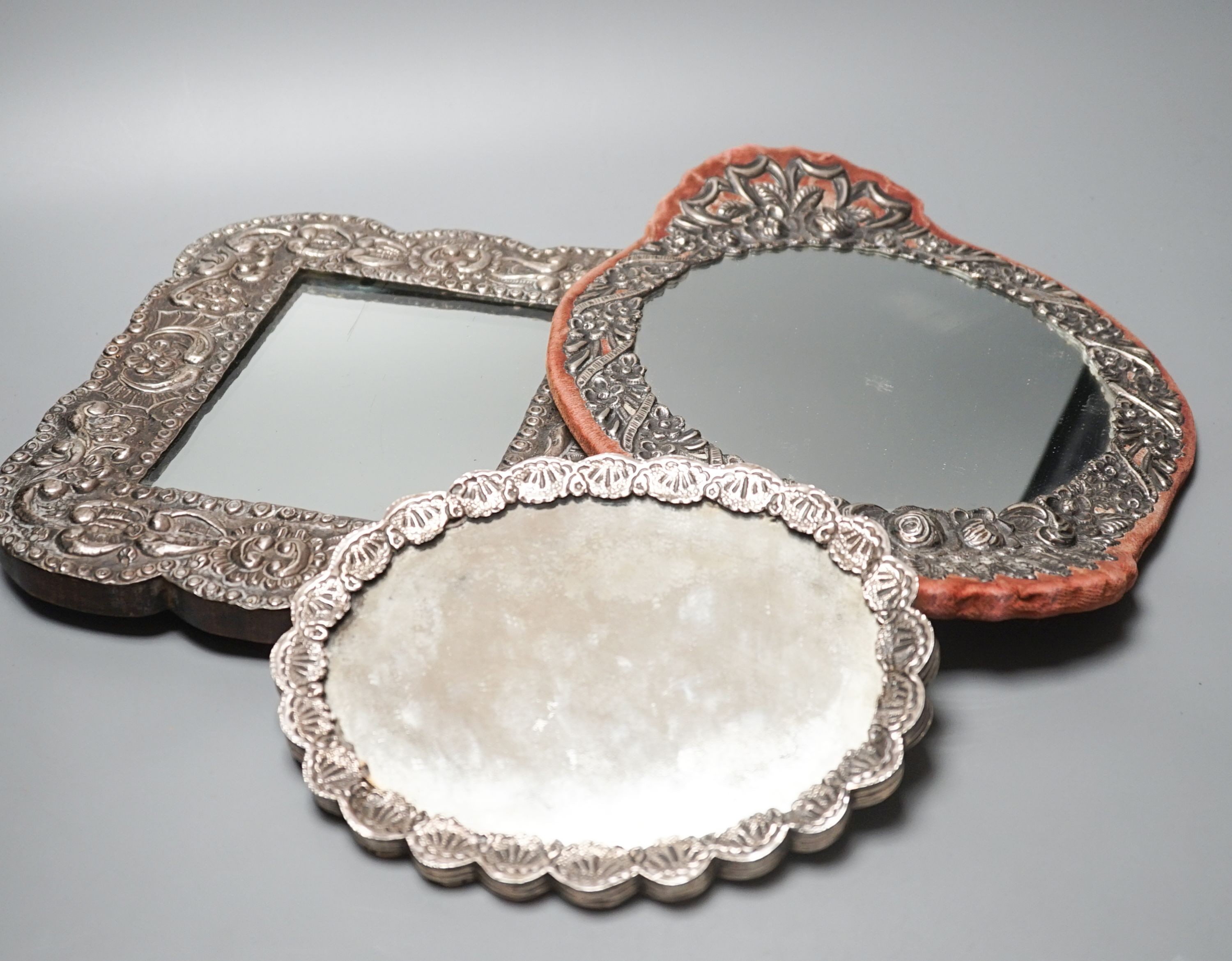 Three assorted Turkish white metal mounted mirrors, largest, 32.2cm.